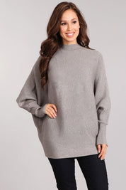 Woman wearing the Celeste Cozy Pullover in gray, featuring a mock neck and dolman sleeves for a relaxed fit.