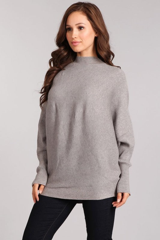 Woman modeling the Celeste Cozy Pullover, a gray rib-knit pullover with dolman sleeves and mock neck.