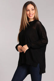 Black oversized crew neck sweater with hi-low hem and fishnet inset, styled with jeans.