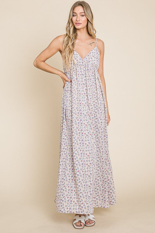 Model wearing the Valencia Floral Dress, a sleeveless maxi with a charming floral print and flattering silhouette.