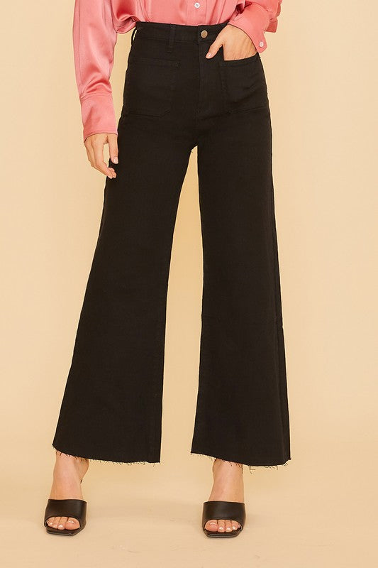 High-rise Renley Wide Leg Jean with a modern cropped length in black denim, styled with a pink blouse and heels.