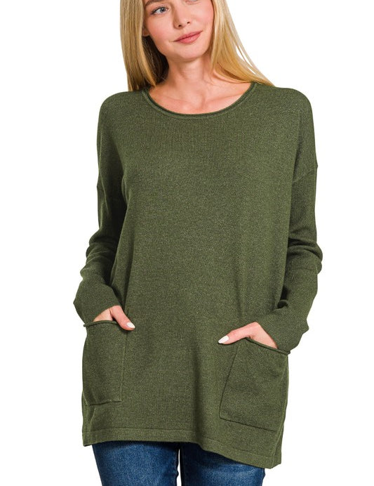 Woman wearing an olive Elara Two-Pocket Sweater with front pockets, paired with jeans for a casual-chic look.