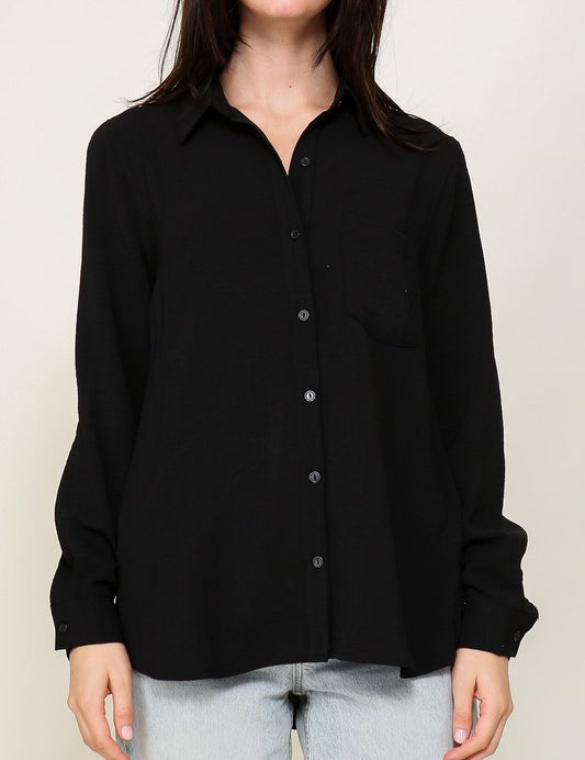 Woman wearing Brooklyn Long Sleeve Blouse, black button-down, collared, paired with light jeans, showcasing an effortless elegant style.