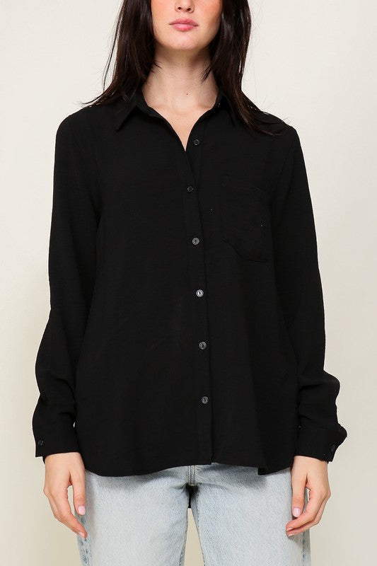 Woman wearing Brooklyn Long Sleeve Blouse, black button-down, collared, paired with light jeans, showcasing an effortless elegant style.