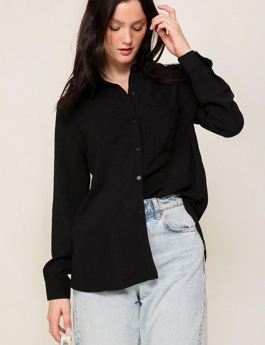 Woman wearing Brooklyn Long Sleeve Blouse in black, showcasing oversized fit and collared neckline for casual chic style.