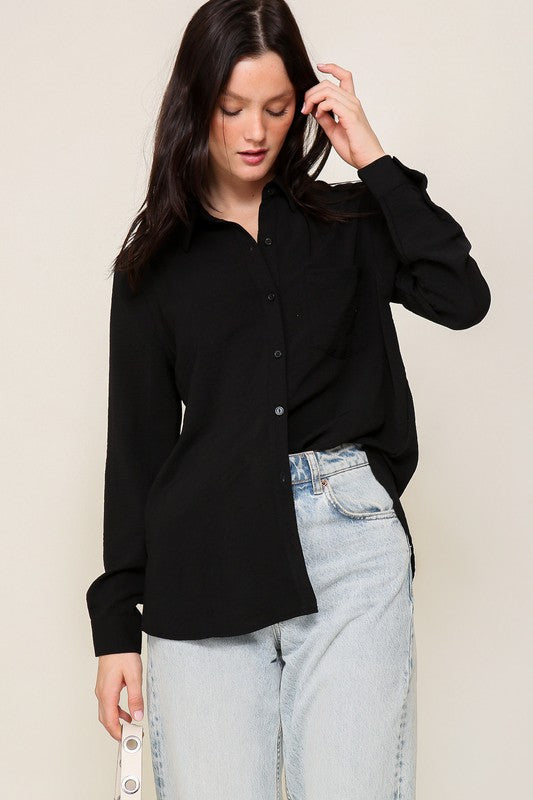 Woman wearing Brooklyn Long Sleeve Blouse in black, showcasing oversized fit and collared neckline for casual chic style.