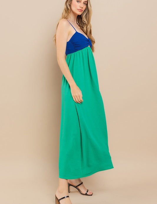 Model wearing Clara Colourblock Dress with blue top and green skirt, showcasing stylish twist-front and adjustable straps.