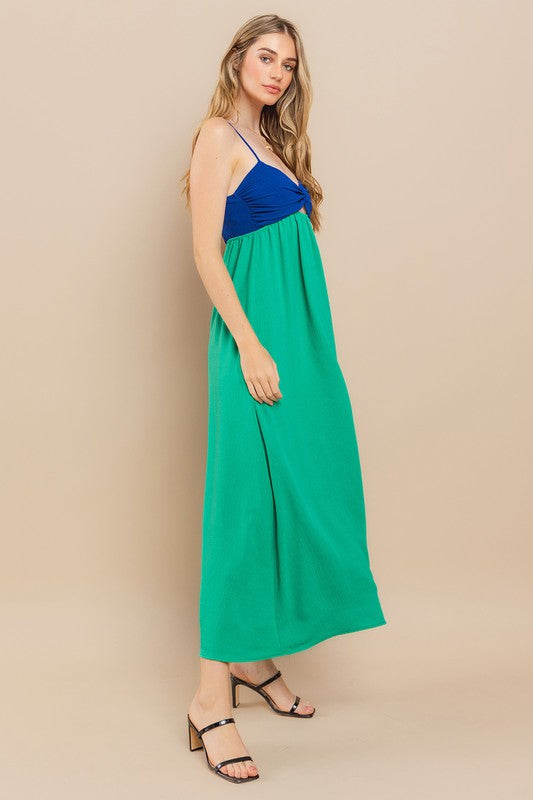 Model wearing Clara Colourblock Dress with blue top and green skirt, showcasing stylish twist-front and adjustable straps.