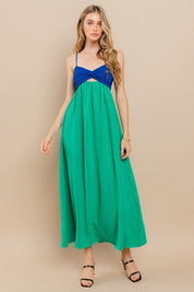 Model wearing Clara Colourblock Dress with twist-front detail in blue and green colorblock design.