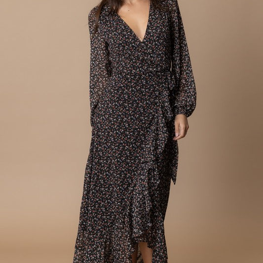 Woman wearing the Echo Floral Wrap Dress, featuring a floral print, wrap design, and flowing silhouette.