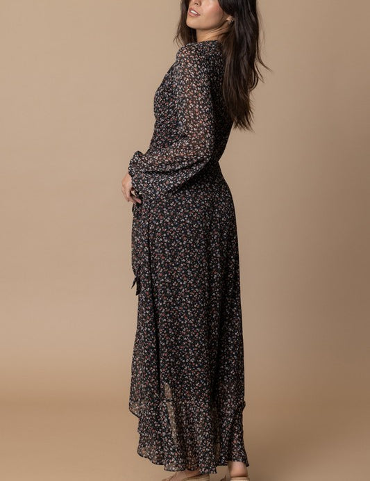 Woman wearing the Echo Floral Wrap Dress, showcasing its elegant floral print and flowing silhouette.