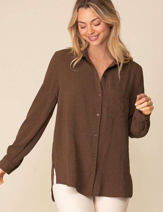 Woman wearing Brooklyn Long Sleeve Blouse in brown with collared neckline and button-down front for a stylish, comfortable look.