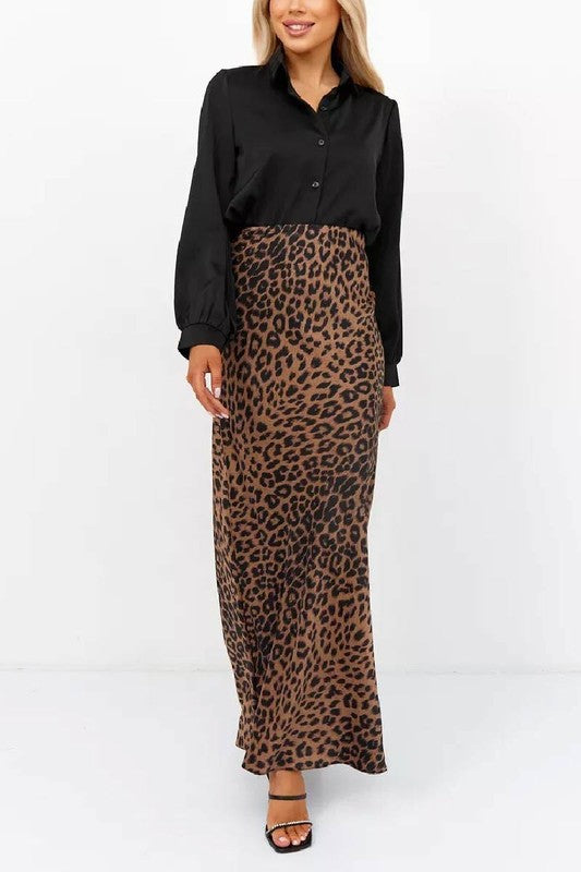 Woman wearing Livia Leopard Satin Skirt with black blouse, showcasing the long, flowing leopard-print design.