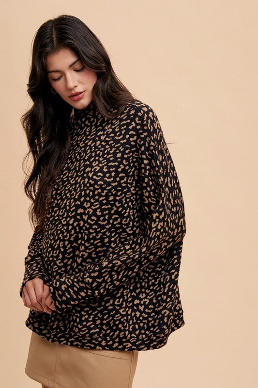 Woman wearing a Kaida Leopard Sweater with mock-neck and animal jacquard knit, showcasing a chic and cozy fashion look.