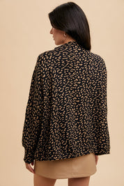 Woman wearing Kaida Leopard Sweater with animal jacquard knit, showing back view and relaxed fit, styled over a tan skirt.