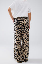 Back view of Savanna Satin Pants in bold leopard print, relaxed fit with elastic waistband and side pockets.