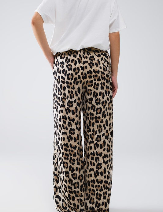 Back view of Savanna Satin Pants in bold leopard print, relaxed fit with elastic waistband and side pockets.