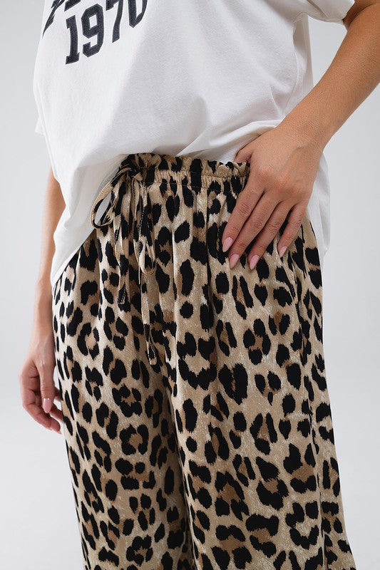 Savanna Satin Pants featuring bold leopard print, relaxed fit, and adjustable drawstring waistband for comfortable summer style.