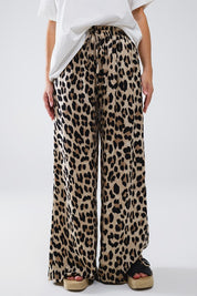 Savanna Satin Pants featuring bold leopard print, relaxed fit, and elasticated waistband for summer elegance.