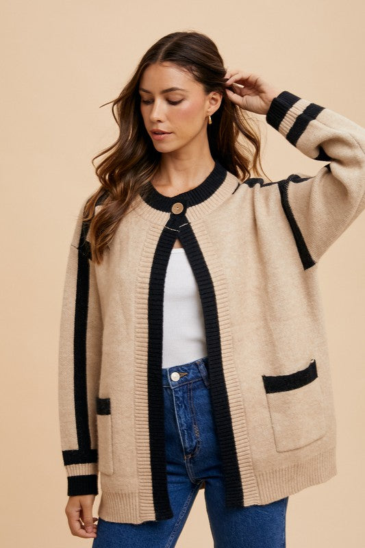 Woman wearing Elowen Sweater Jacket with black contrast lines and patch pockets, styled casually with jeans and a white top.