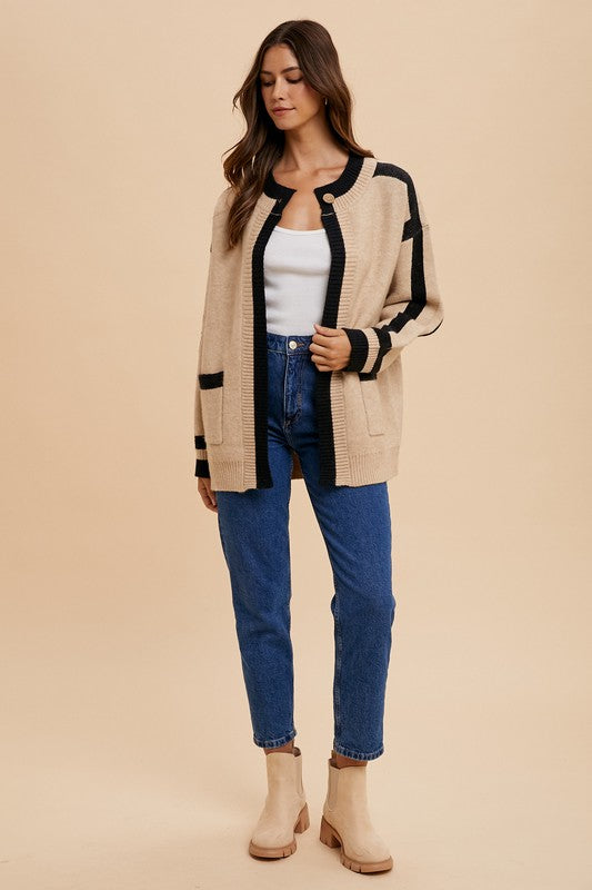 Woman wearing beige Elowen Sweater Jacket with contrast lines and patch pockets, styled with jeans and boots.