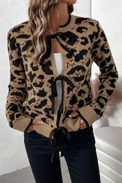 Woman wearing the Savannah Leopard Bow Cardigan with chic leopard print and bow tie front, styled for casual and evening outings.