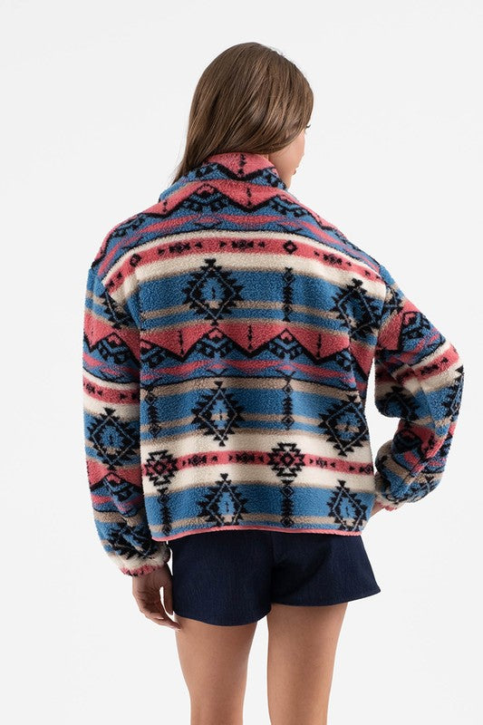 Woman wearing a colorful Sierra Tribal Shawl Jacket with a high neck and tribal print, showcasing a bold and cozy style from the back.