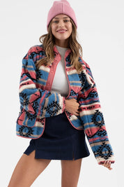 Woman wearing Sierra Tribal Shawl Jacket with tribal print, high neck, shawl collar, and snap button closure for a cozy winter look.