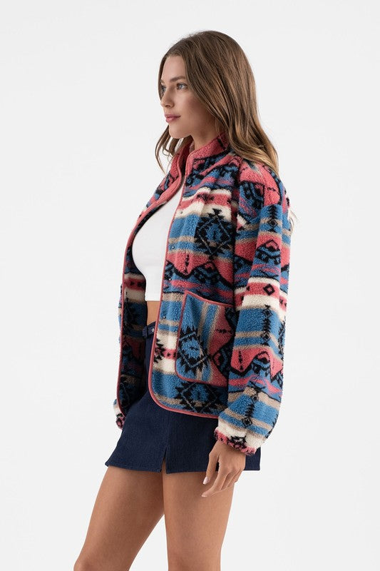 Woman wearing Sierra Tribal Shawl Jacket with colorful tribal print, high neck, and shawl collar for stylish warmth.