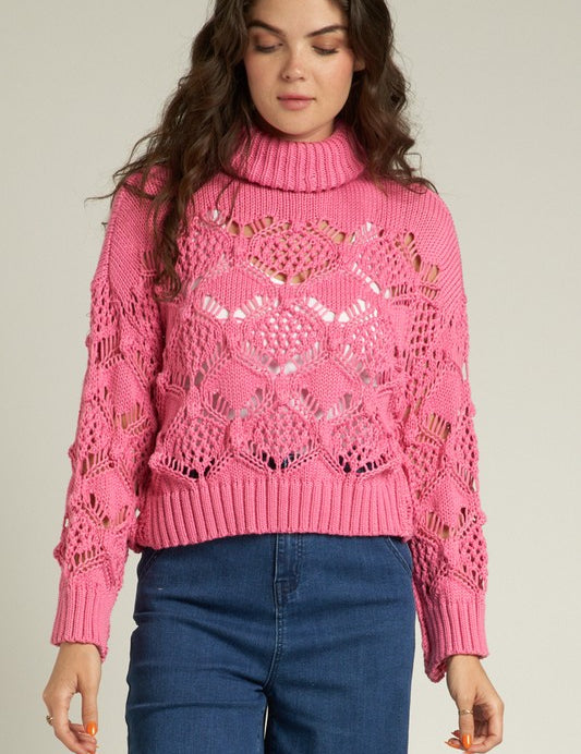 Cropped pink Scarlette Crochet Sweater with turtleneck, featuring intricate crochet design paired with high-waisted jeans.