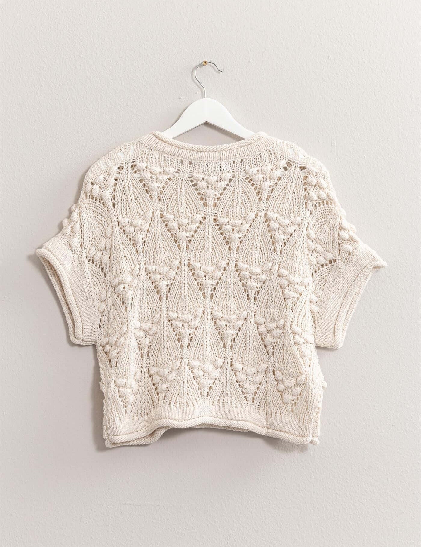 Kate Knit TopThe Kate Knit Top is a perfect blend of style and comfort. This crochet knit short sleeve top features an intricate crochet pattern that adds a touch of vintage charm. The short sleeves and lightweight fabric make it ideal for warm weather, w