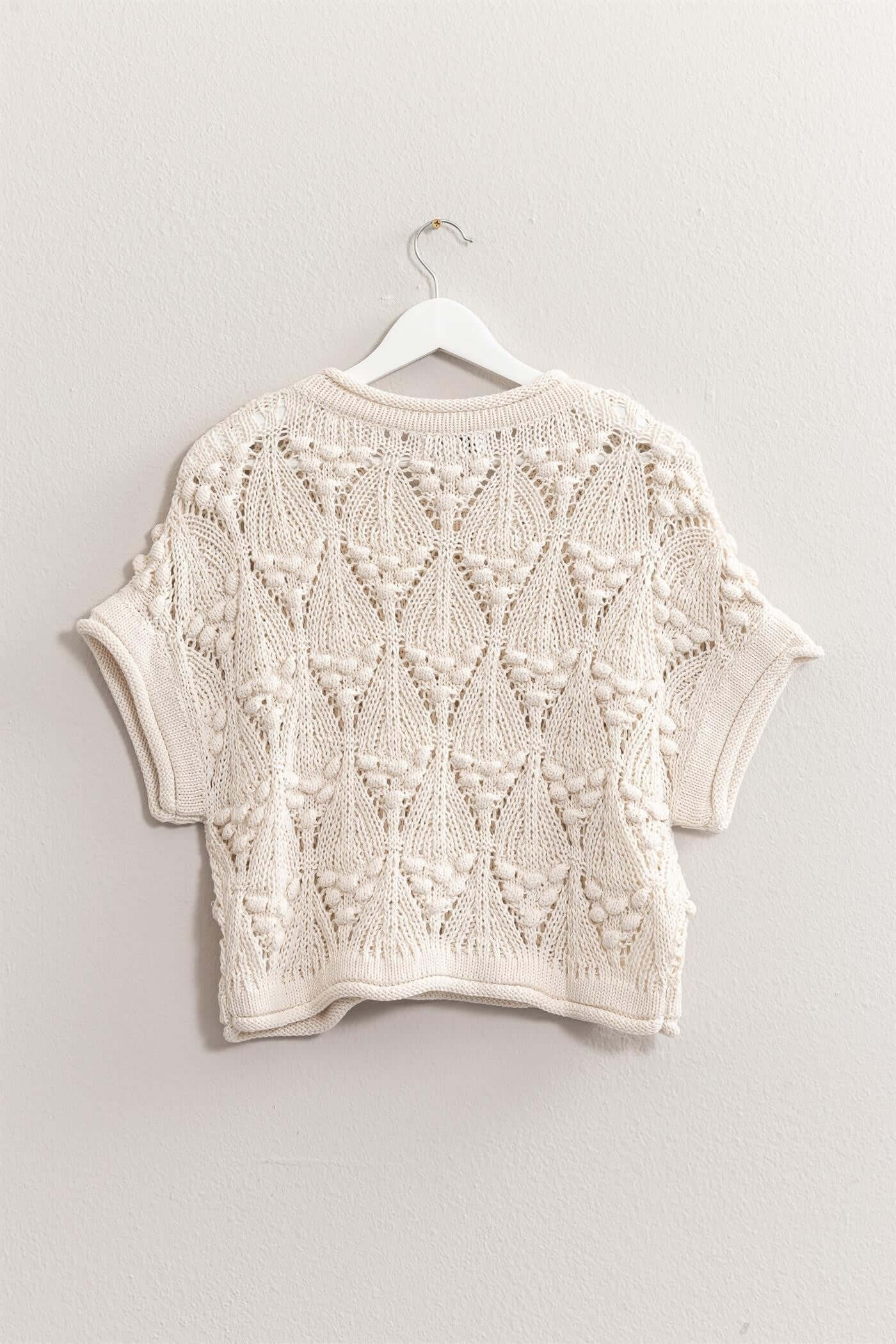 Kate Knit TopThe Kate Knit Top is a perfect blend of style and comfort. This crochet knit short sleeve top features an intricate crochet pattern that adds a touch of vintage charm. The short sleeves and lightweight fabric make it ideal for warm weather, w