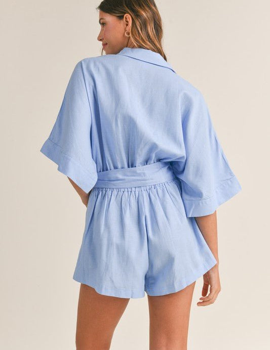 Cali Button Front RomperIntroducing our Cali Solid Button Down Collared Romper, the versatile piece your summer wardrobe has been craving! Crafted with comfort and style in mind, this romper features short sleeves, a classic button-down front, and a sophi