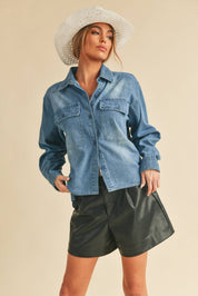 Genny Denim TopRevamp your style with this Genny faded denim shirt. Featuring button closure, spread collar, and long sleeves with button cuffs. The high-low hem adds a touch of edge, while the button-close chest pockets offer functionality and flair. Ele