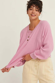 Rose Raglan TopThe Rose Raglan Crew combines comfort and style with its relaxed silhouette. Featuring a classic Henley design with a button placket, this long sleeve top is crafted from soft, textured waffle knit fabric that adds a cozy feel. The raglan s