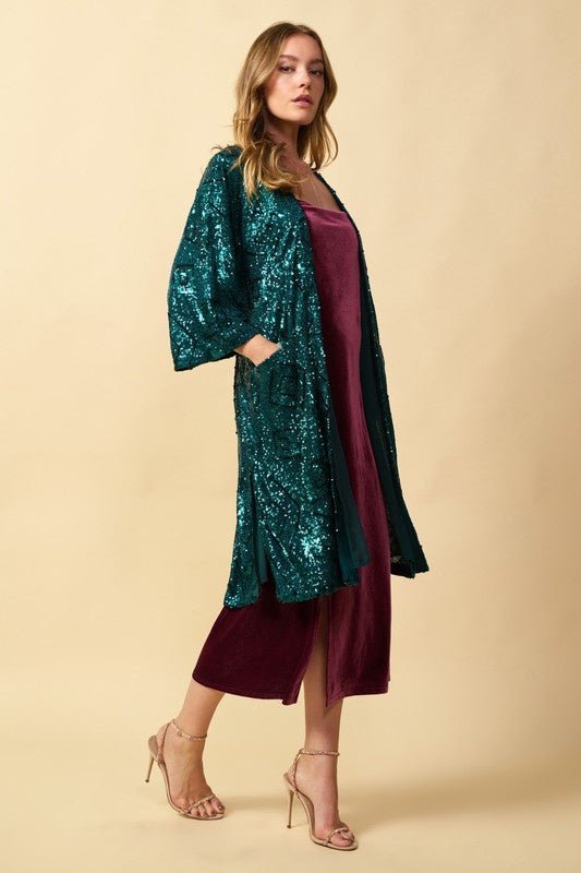 Madeline Sequin Kimono - FINAL SALEDESCRIPTION: Sequined midi length kimono with waist tie, 3/4 bell sleeves, and front pockets. Made In: Imported Content: body 95% Polyester / 5% Spandex lining 100% Polyester Washing Instructions: Dry Clean Only Fit: TTS