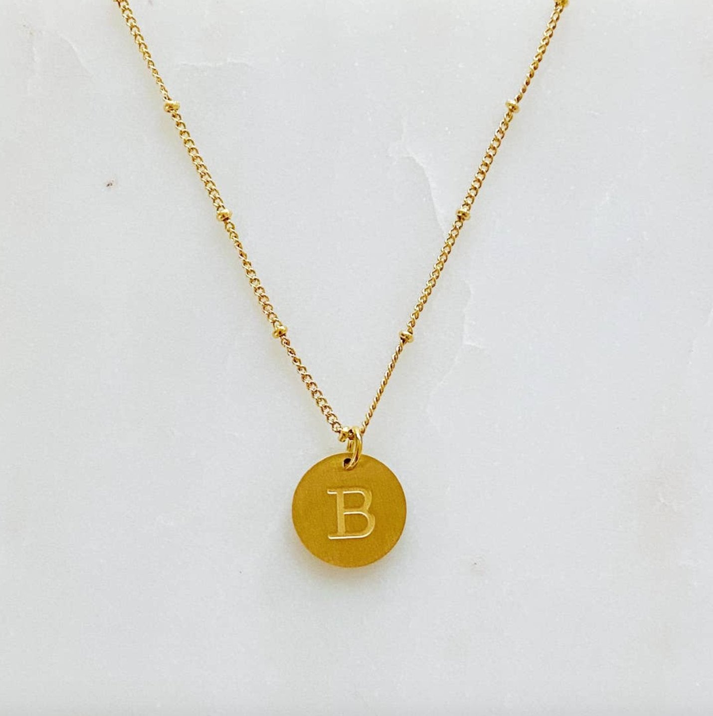 Singular Charm Initial NecklaceGold plated coin initial necklace. Absolutely adorable for engraved charm with dainty chain that has tiny balls in between. Has great quality and details. Stainless steel gold plated. Lead and Nickel Free 16 inch chain with