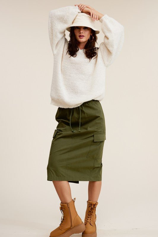 Ulla Cargo Pocket SkirtCombine the details of your favorite cargo pants with the sophisticated silhouette of a midi skirt with this stunning piece. It features a mid-rise, elasticated waistband with drawstring, and a slit at the back for added comfort and