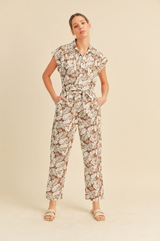 Viana Button Down Jumpsuit - FINAL SALEBe ready for adventure in the Viana Jumpsuit! This utility inspired jumpsuit features a summery botanical print with a button front top with chest pockets, a partially elasticated waist with a tie, and a straight leg