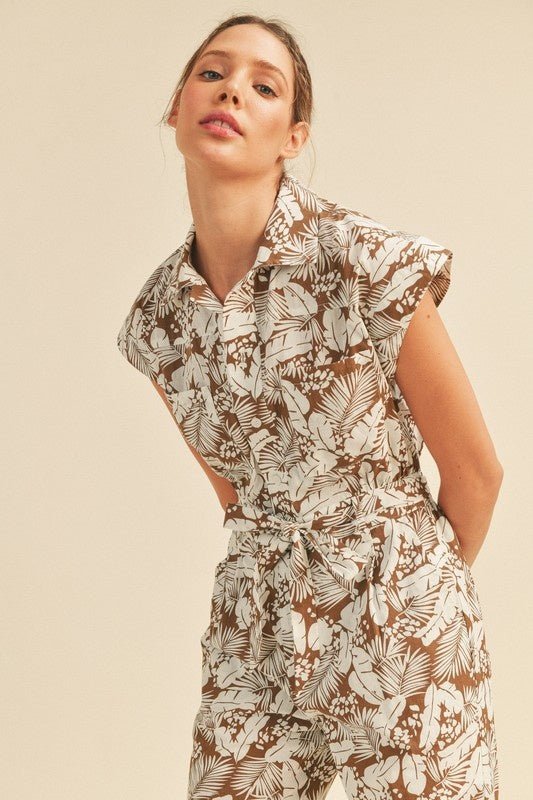 Viana Button Down Jumpsuit - FINAL SALEBe ready for adventure in the Viana Jumpsuit! This utility inspired jumpsuit features a summery botanical print with a button front top with chest pockets, a partially elasticated waist with a tie, and a straight leg