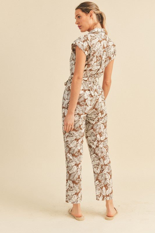 Viana Button Down Jumpsuit - FINAL SALEBe ready for adventure in the Viana Jumpsuit! This utility inspired jumpsuit features a summery botanical print with a button front top with chest pockets, a partially elasticated waist with a tie, and a straight leg