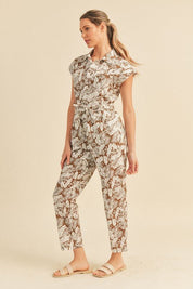 Viana Button Down Jumpsuit - FINAL SALEBe ready for adventure in the Viana Jumpsuit! This utility inspired jumpsuit features a summery botanical print with a button front top with chest pockets, a partially elasticated waist with a tie, and a straight leg